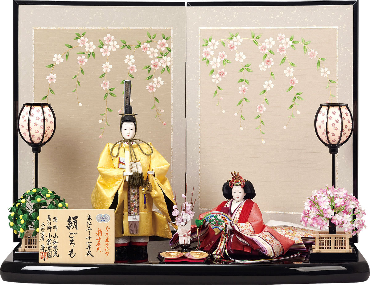 A modern pair of ornate hina dolls dressed in...