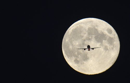 clarincomhd:Un avión de pasajeros, con fondo de luna llena,...