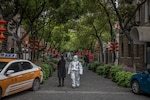 Une personne portant un équipement de protection complet marche dans les rues de Wuhan, Chine, 30 mars 2020.