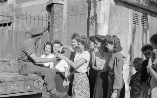 demons:French girls pour a drink for a British soldier in...