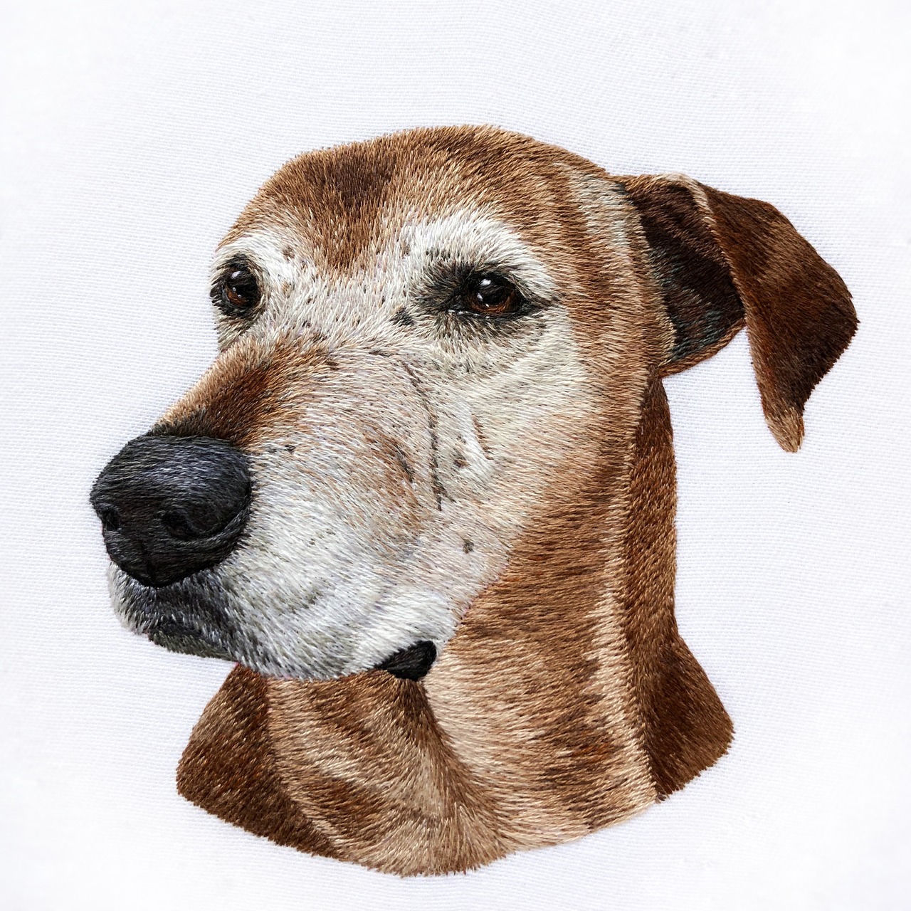 Hand embroidered dog portrait on cotton. See more @stitchingsabbatical on Instagram.