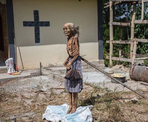 sixpenceee:
“From @brianlehmannphotography. During a rare death ritual family members change the clothing of Lingbong Bua’, thought to be 110 years old, when she died 8 years ago in Indonesia. They propped her body up against a stick to take...