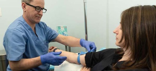 Dr. Alexeyenko with a patient during an IV therapy session. 