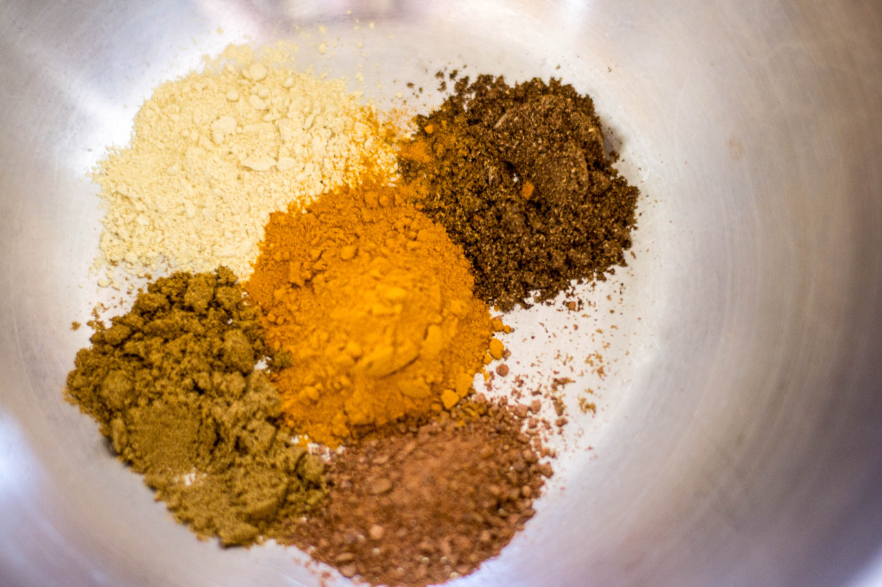 Spices, clockwise from left: fenugreek, baharat, cinnamon, cumin, and turmeric in the middle.