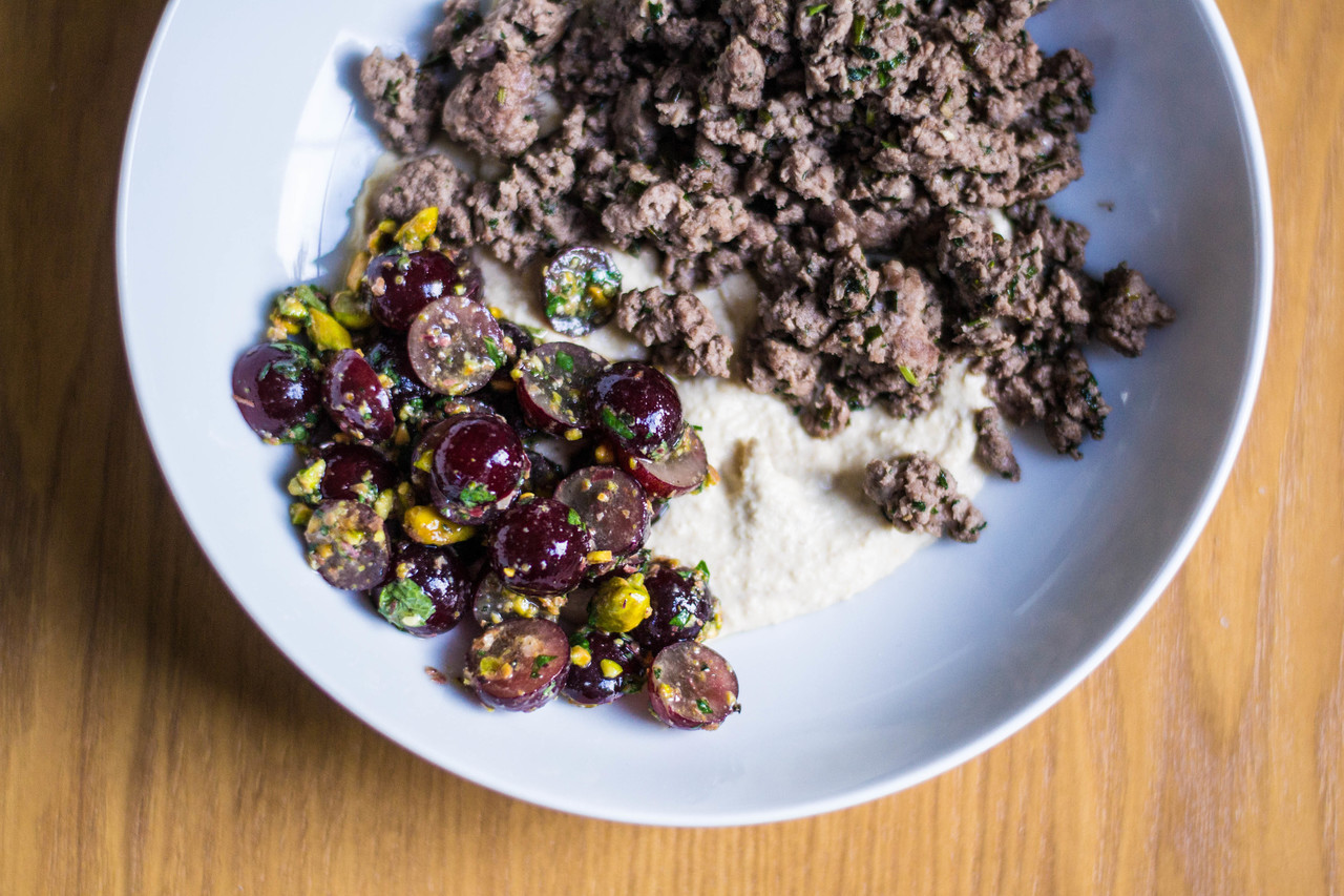 Baharat-spiced lamb with grape-pistachio salad and Zahav hummus tehnia