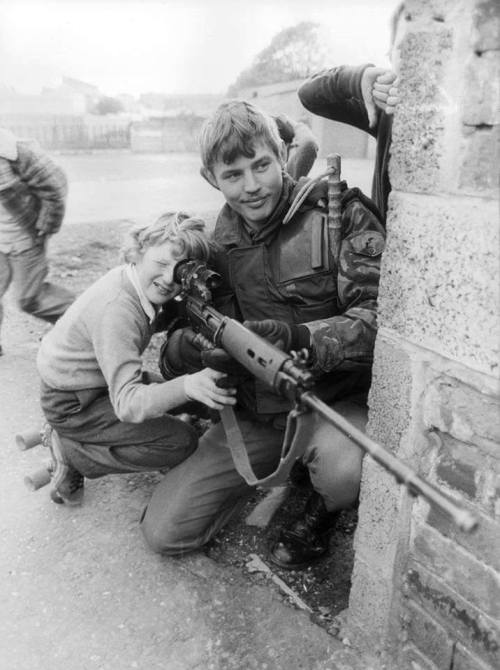 greasegunburgers:A British squaddie lets an Irish child look...