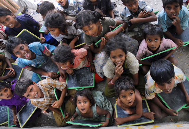 Children from a slum study at a roadside school in... - The world isn't ...