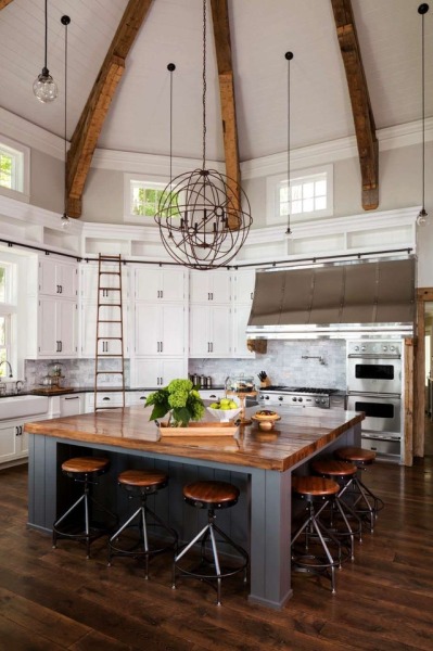 Open kitchen with a vaulted ceiling and large central wooden island in this home in Big Cedar Lake, Wisconsin. [932 × 1400]