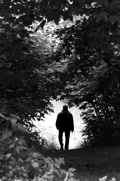 PKH Photography | Solitary man walking down a narrow wodden path in...