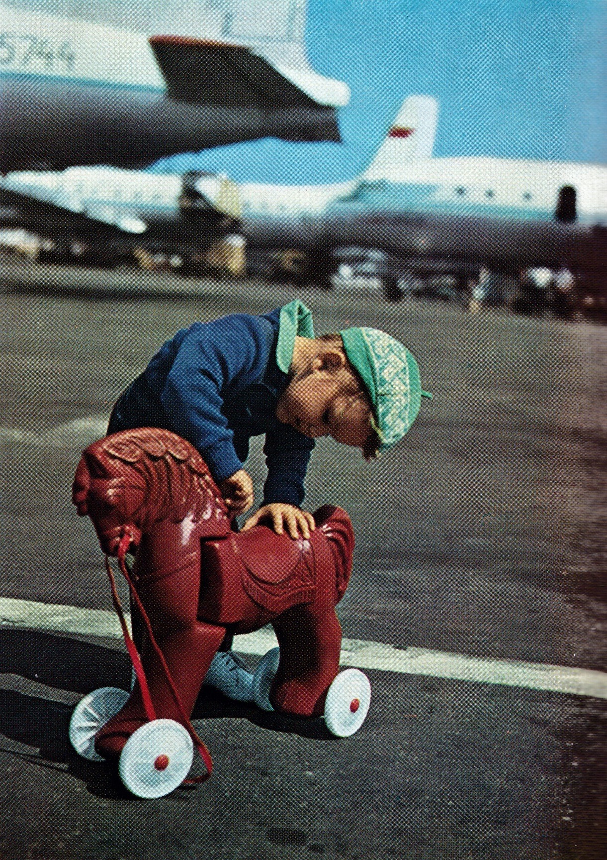 A boy playing with his toy horse. Sheremetyevo airport in Moscow (1970s)