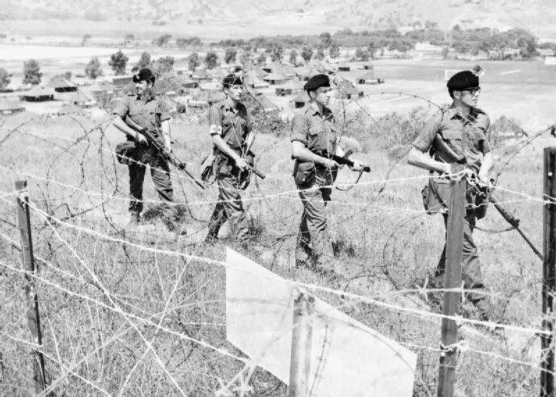 Mostly Military? — British Troops Patrol The Perimeter Of Their Base...