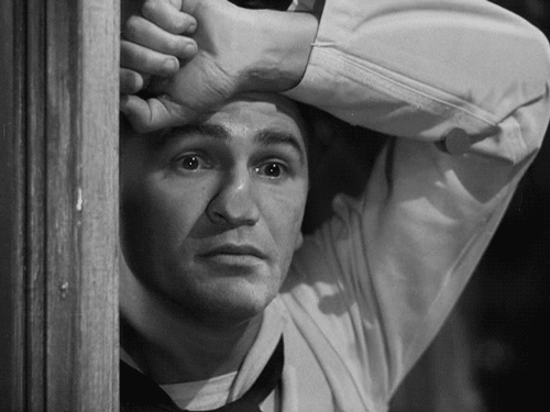 John Garfield presiona su cara contra el cristal para espiar a una dama en Destino Tokio (1943).
