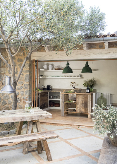 Small, rustic kitchen tucked behind folding glass doors in this stone home in Spain. [600 × 840]