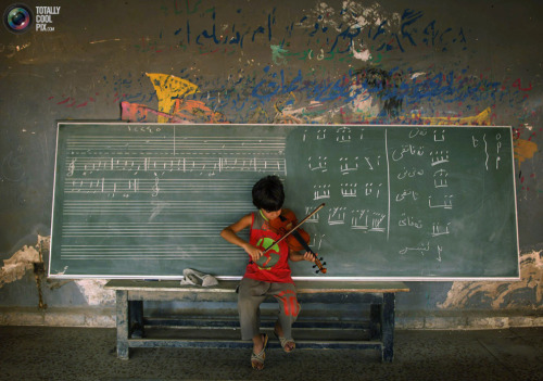 xafat:A boy plays the violin at Sulaimaniya Music Institute in...