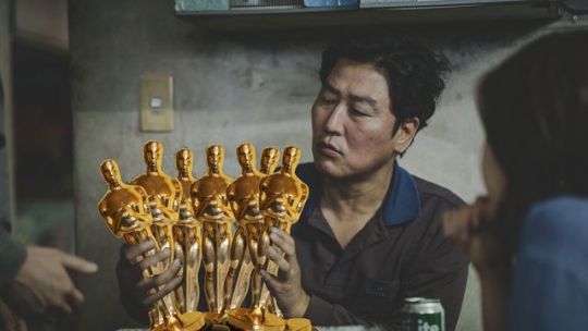 the guy from parasite holds a bunch of oscar statues