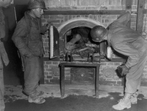 historicaltimes:Three U.S. soldiers look at bodies stuffed into...