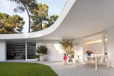 ombuarchitecture:<br /><br />House in Aroeira<br />Due to the absence of fences, the hexagonal shape of the plot is not clear and the ground blends with the surrounding pinewoods. The house occupies the maximal area of construction, concentric to the six-sided plot. Disposed round a courtyard to which every space converges, its peculiar form finds a precise boundary in the outline of the canopy. Service areas provide geometry and stability to the main spaces.<br />By Aires Mateus<br />Photos by FG+SG