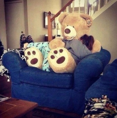 girl cuddling with giant teddy bear