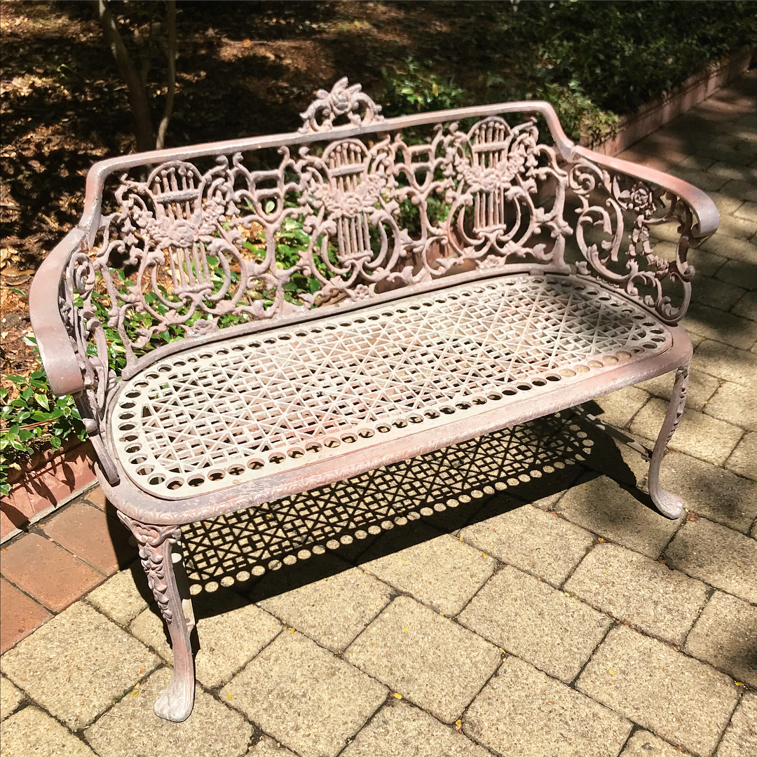 , Antique cast metal bench seat with a Belle Ã‰poque