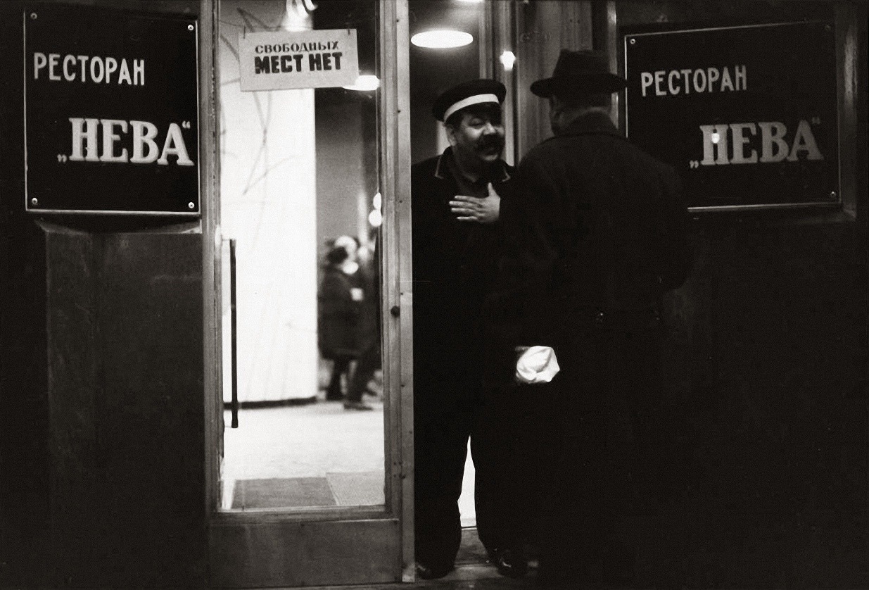 Famous photo by Vsevolod Tarasevich. Doorman of the Neva restaurant in Leningrad, 1960s. The sign on the door says “No tables available.”