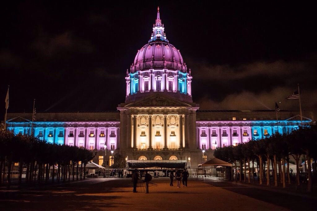 San Francisco City Hall lit up with the Trans flag...