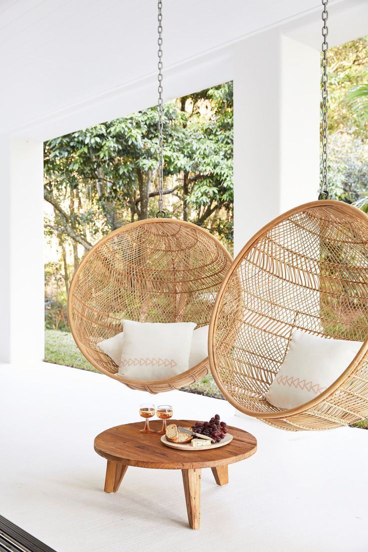 Hanging rattan chairs with white cushions