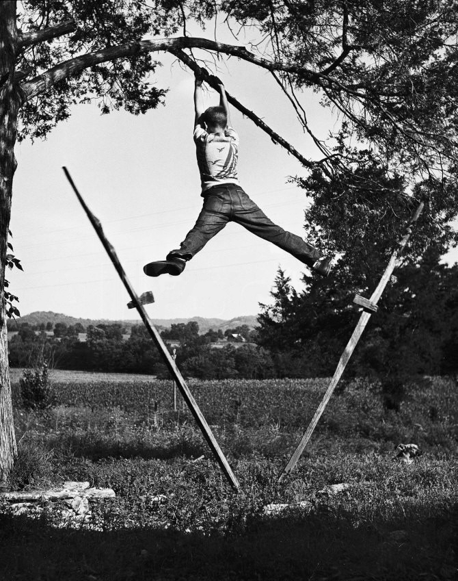 Kenneth Merriman Swinging on Tree Limb after Kicking Away 