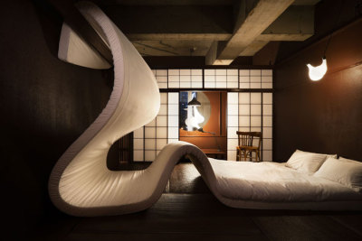 i. Room 302 designed by Yuko Nagayama: The room is completely white.  Upon first glance you only see wood and white pebbles everywhere.  According to the designer “this makes the space change instantly as if snow falls in a city landscape; gaps in time and material link up naturally.”  The space seems uncomfortable at first with only rough pebbles to walk on “The space does not adapt itself to you, but you adapt to it.  The space awakens a latent natural instinct that everybody appears to carry within but is normally not activated.”<br />ii. Room 308 designed by Pieke Bergmans: Light and optical illusion are at play in this room ”…it’s not just about the light in this room. You think you enter a regular hotel-room, but when you have a closer look, you see that the objects behave peculiar; the bed is crawling up the wall. The chair is desperately stretching out to get closer to the table. The lights are entangled and the toothbrushes are totally into one and another. But what else would you expect from a LLove hotel… everything has fallen in LLove!”