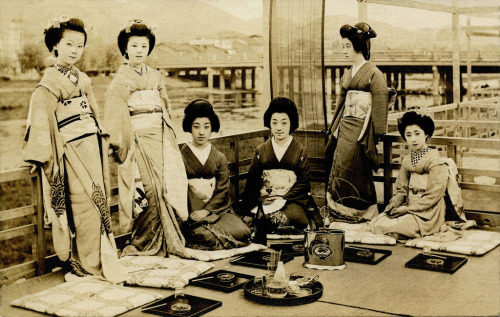 Geiko Tomigiku i przyjaciele na letnim balkonie (1920) (autor: Blue Ruin1) Od lewej do prawej: (stojąc) Maiko Fumiryu, maiko Kohisa i Geiko Danko (klęcząc) geiko Tomigiku, geiko Ichiyuu i maiko Momotaro