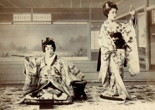 A Maiko in Two Poses (1900)
“A trick photograph of a Maiko (Apprentice Geisha) in two different poses. On the left-hand side of the image she is seated on a Zabuton (floor cushion) with one arm leaning on a Kyosoku (arm rest) and the other holding a...