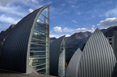 modernizing:<br /><br />Located in Arosa, Switzerland, this hotel’s wellness center was created by Architect Mario Botta with not only healing properties from within– but a beautiful piece of architecture to create positive energy from the outside as well. Built in 2006, this gorgeous Tschuggen Grand Hotel and Wellness Centre (or Berg Oase) is mainly level with the ground with the exception of the metaphorical trees that stick up and protrude through the deep snow in the winter months. Discreet integration was a main concern of the planning, and a glazed walkway connects the centre with the hotel– keeping things clean and continuous. At night the Berg Oase becomes a magically lit place, showing the life and ongoings within.