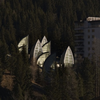 modernizing:<br /><br />Located in Arosa, Switzerland, this hotel’s wellness center was created by Architect Mario Botta with not only healing properties from within– but a beautiful piece of architecture to create positive energy from the outside as well. Built in 2006, this gorgeous Tschuggen Grand Hotel and Wellness Centre (or Berg Oase) is mainly level with the ground with the exception of the metaphorical trees that stick up and protrude through the deep snow in the winter months. Discreet integration was a main concern of the planning, and a glazed walkway connects the centre with the hotel– keeping things clean and continuous. At night the Berg Oase becomes a magically lit place, showing the life and ongoings within.